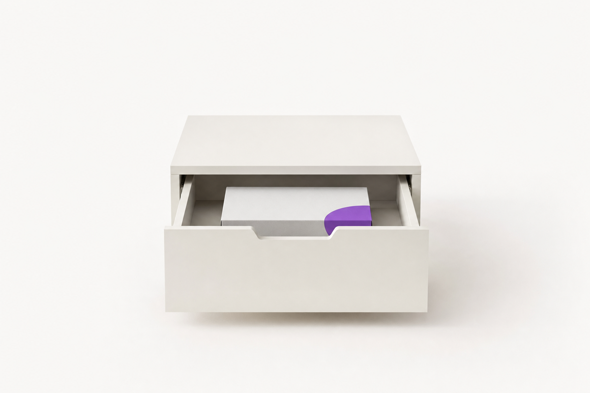 Un cajón de escritorio entreabierto con una caja de software cerrada dentro